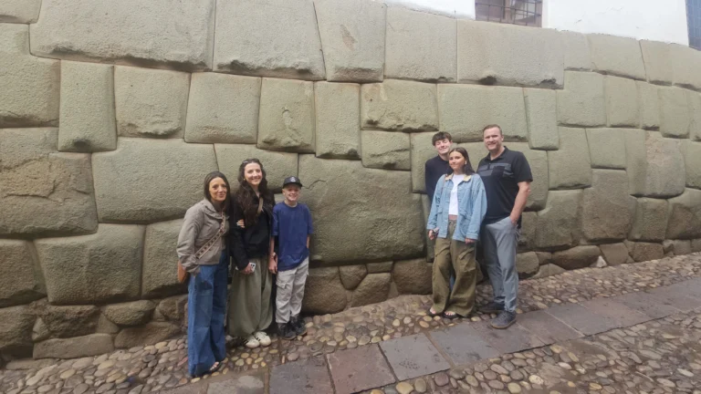 Turistas observando la famosa Piedra de los 12 ángulos en la calle Hatun Rumiyoc.